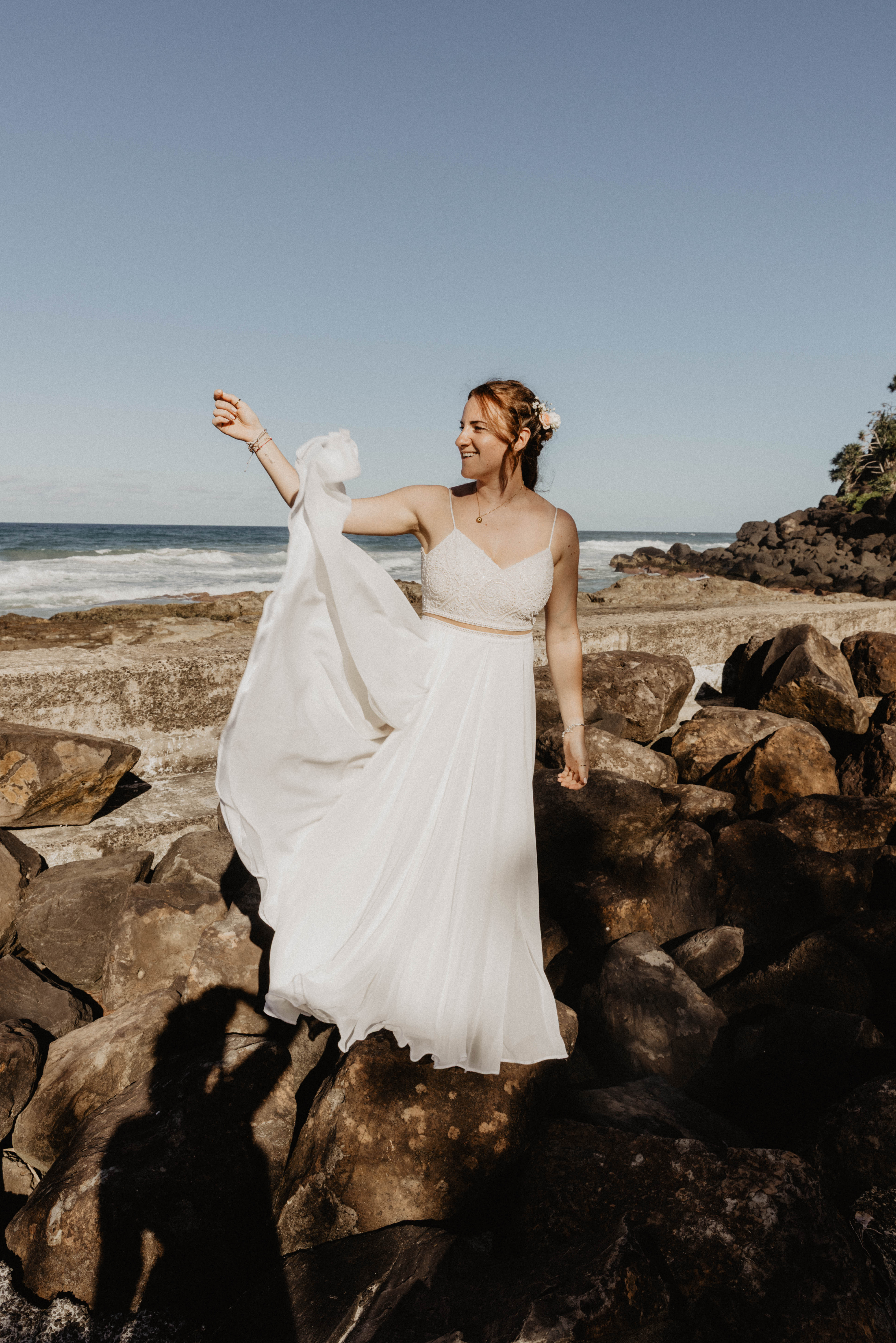 bride celebrating on rocks sunset wedding Coolangatta